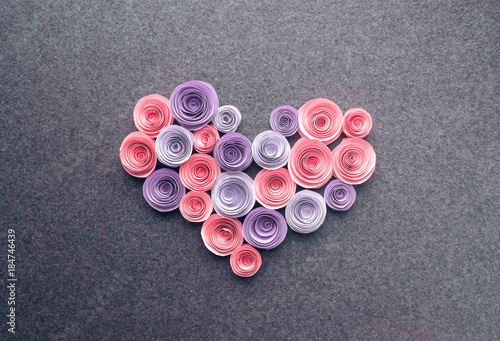 Handmade paper flowers heart on dark felt background. Beautiful Pink, lilac, purple paper roses in the form of heart. Greeting card. Love romance concept