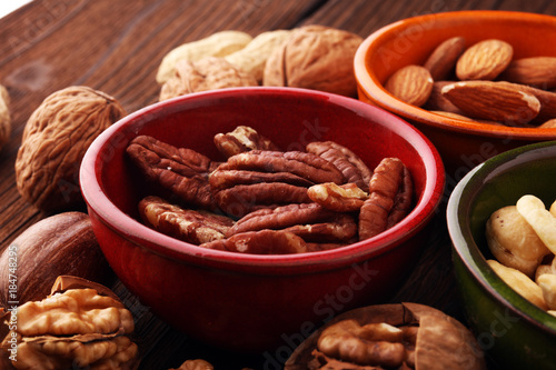 bowls with mixed nuts on wooden background. Healthy food and snack. Walnut, pecan, almonds, hazelnuts and cashews.
