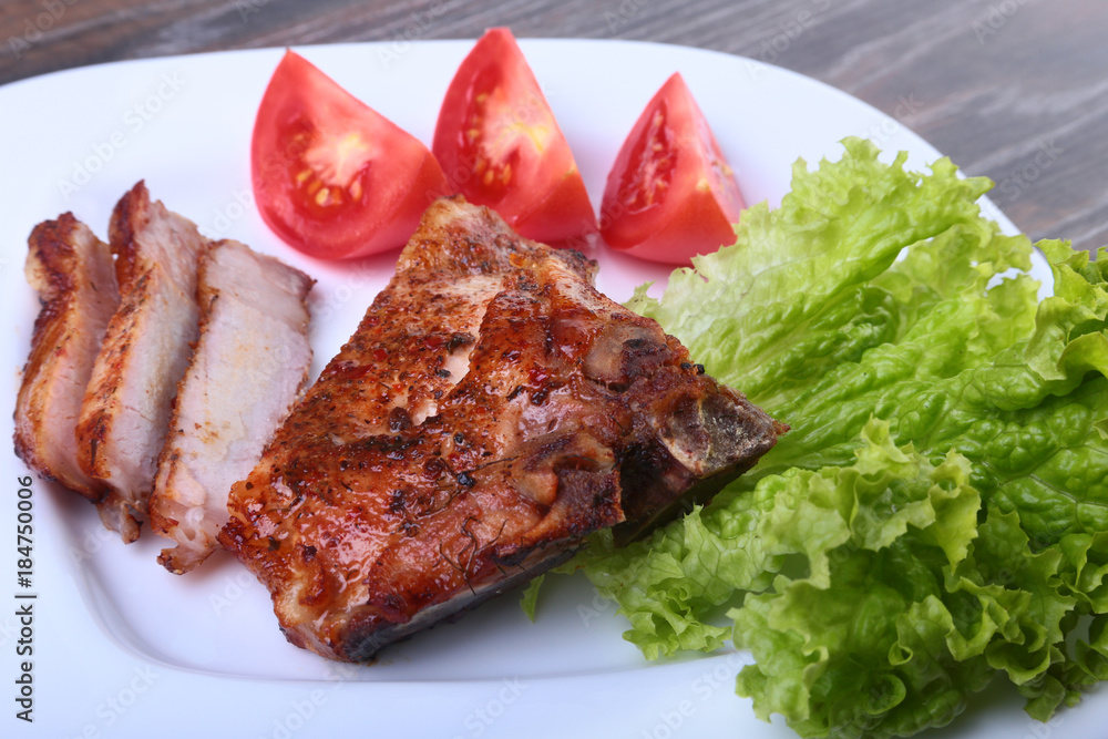 grilled pork chops with tomato, leaves lettuce and ketchup on plate. grilled pork chops with tomato, leaves lettuce and ketchup on plate.