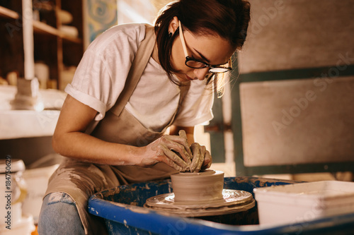Female potter making a clay bowl