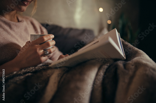 Female reading book on bed at night