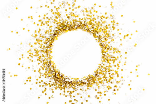 Golden shiny confetti on a white background. Round frame made of confetti. Festive confetti.