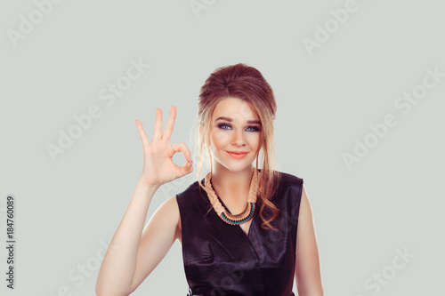 Everything will be alright. Beautiful young happy woman showing Ok sign isolated on light gray wall background. Positive human emotions face expression body language gesture