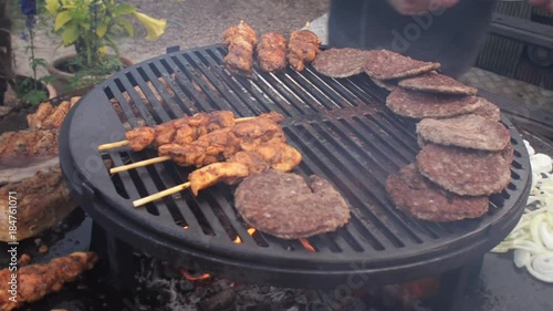 garden barbecue turning chicken kebabs  photo