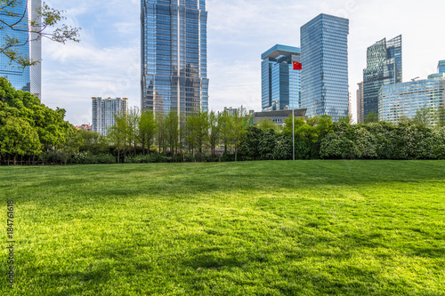 cityscape and skyline of shanghai from meadow in park.