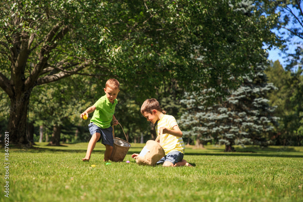children looking for Easter eggs in the grass. the concept of Easter eggs hunting children looking for Easter eggs in the grass. the concept of Easter eggs hunting