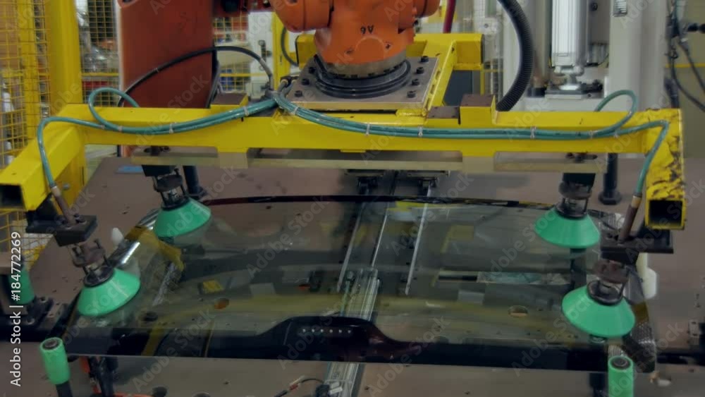robot is gripping a back car windows and lifting up in a car factory robot is gripping a back car windows and lifting up in a car factory