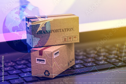 Two small cardboard boxes with world map on a laptop keyboard. An idea of International freight or shipping service for online shopping or ecommerce concept. freight forwarding business concept.