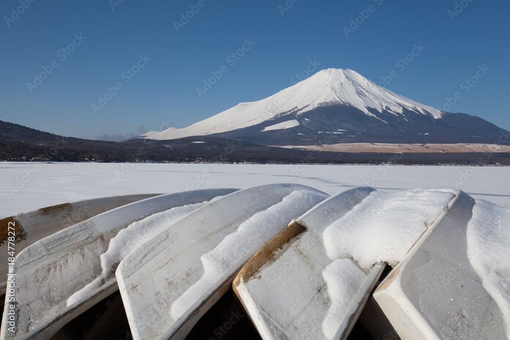 Mountain Fuji and Paddle boats out of service in winter season at Yamanakako lake , Yamanashi prefecture , Japan