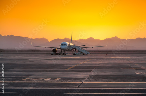 Airplane in the Evening Against the Backdrop of the Mountains
