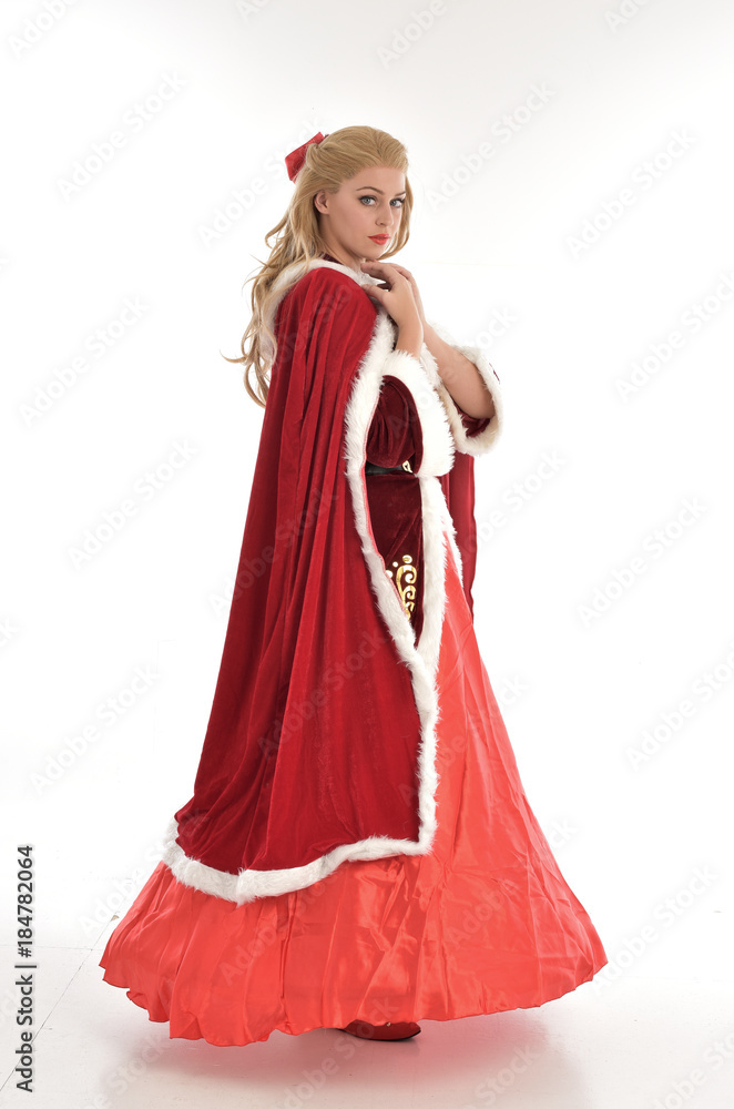 full length portrait of pretty blonde lady wearing red and white christmas inspired costume gown, standing pose on white background. full length portrait of pretty blonde lady wearing red and white christmas inspired costume gown, standing pose on white background.