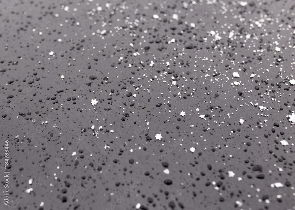 Snowflakes on a black car as a background Snowflakes on a black car as a background