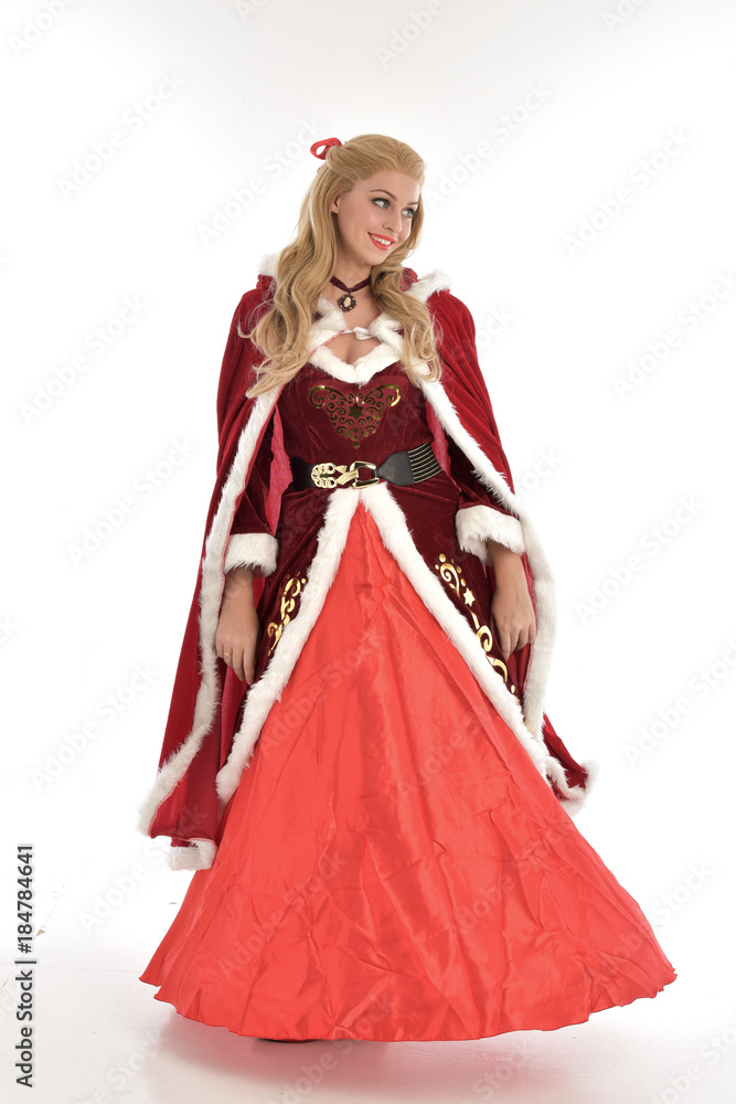 full length portrait of pretty blonde lady wearing red and white christmas inspired costume gown, standing pose on white background. full length portrait of pretty blonde lady wearing red and white christmas inspired costume gown, standing pose on white background.