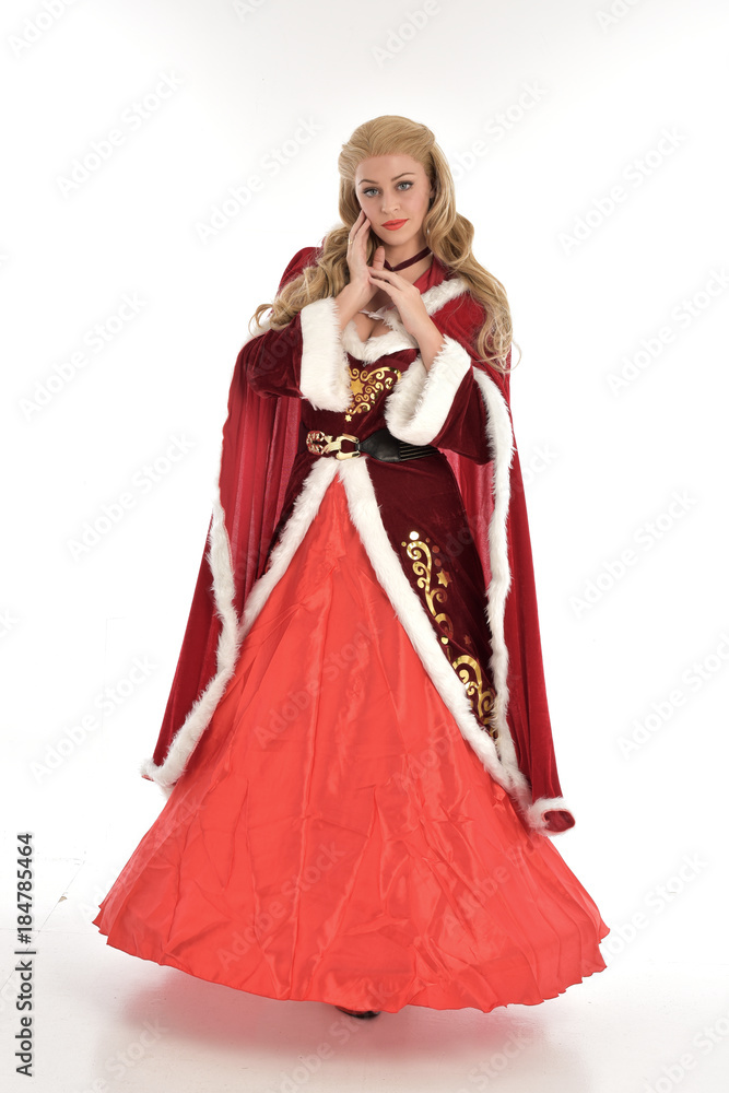 full length portrait of pretty blonde lady wearing red and white christmas inspired costume gown, standing pose on white background. full length portrait of pretty blonde lady wearing red and white christmas inspired costume gown, standing pose on white background.