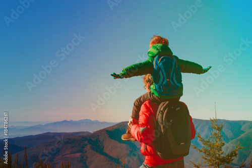 happy father and son play on sky, travel in mountains