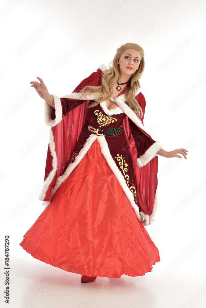 full length portrait of pretty blonde lady wearing red and white christmas inspired costume gown, standing pose on white background. full length portrait of pretty blonde lady wearing red and white christmas inspired costume gown, standing pose on white background.