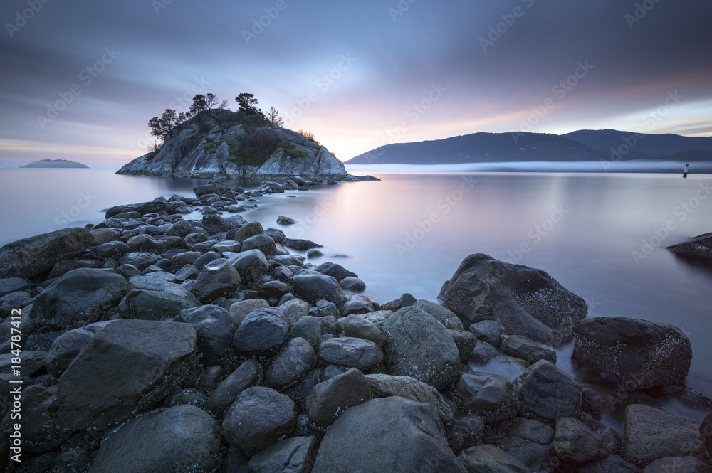 Obraz premium Fog and mist roll into Whytecliff Park at sunset producing some vivid colors in West Vancouver BC Canada.