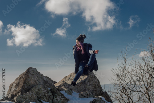 Young beautiful woman posing on cliff