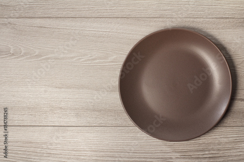 Empty ceramic plate on grey wooden background with copy space