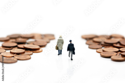 Miniature People : businessman walking between stack of coins