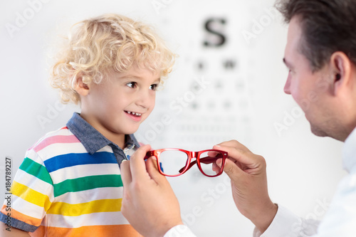 Child at eye sight test. Kid at optitian. Eyewear for kids. photo