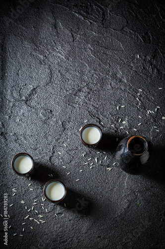 White sake in black ceramics on black rock