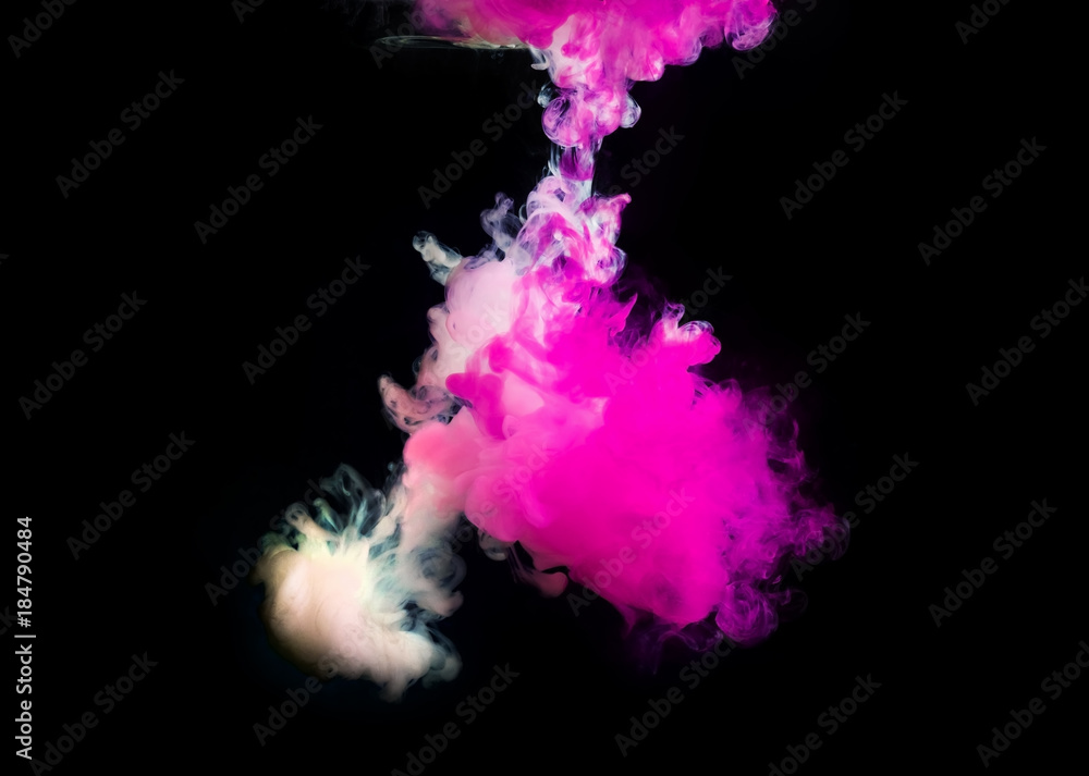Pink and white paint in water on black background.