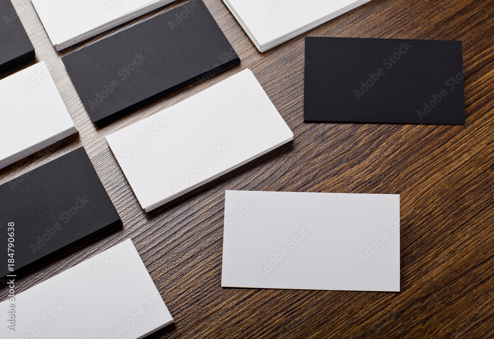 Mockup of white and black business cards at wooden background Mockup of white and black business cards at wooden background