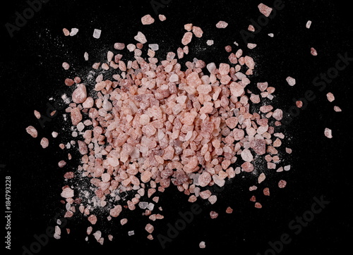 Himalayan salt grains isolated on black background, top view