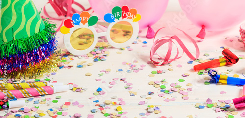 Birthday party. Confetti and serpentines on wooden background