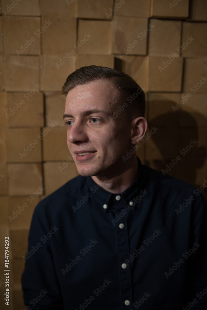 Portrait of handsome young man in a hat. He is in of darkroom coffee shop background. Confident and trendy look. Portrait of handsome young man in a hat. He is in of darkroom coffee shop background. Confident and trendy look.