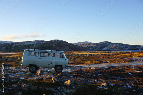 Vintage blue van parking on tundra arctic landscape