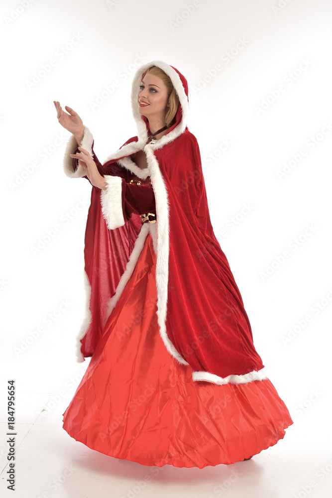 full length portrait of pretty blonde lady wearing red and white christmas inspired costume gown, standing pose on white background. full length portrait of pretty blonde lady wearing red and white christmas inspired costume gown, standing pose on white background.