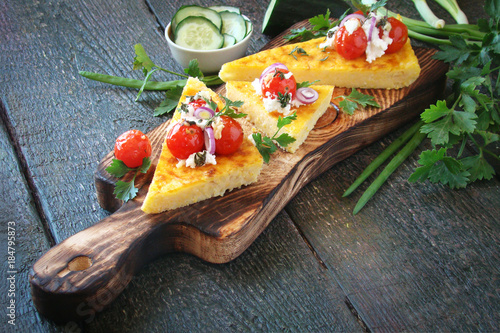 Fotografia Corn polenta with Parmesan, roasted tomatoes, goat cheese