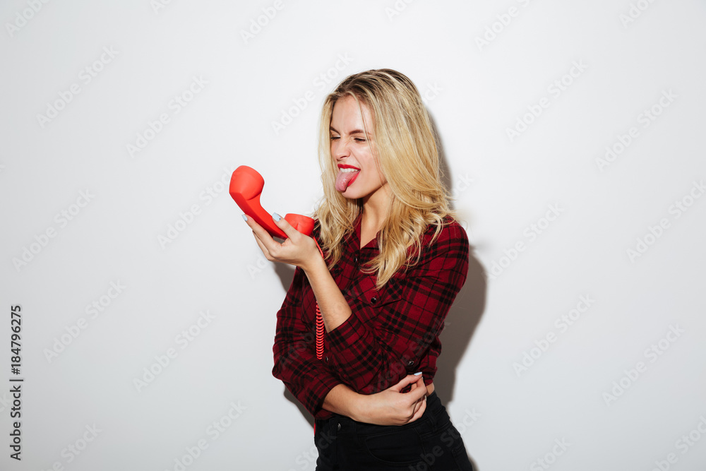 Screaming woman talking by red retro telephone. Screaming woman talking by red retro telephone.