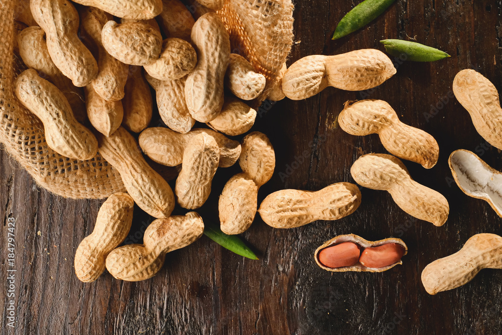 Fototapeta premium Composition of peanuts serving to make oil, peanut butter. Great for healthy and dietary nutrition. Concept of: condiments, dried fruit, food.