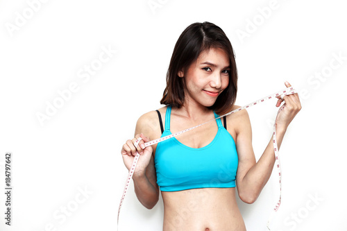 woman diet background fitness concept happy weight loss beautiful body calories healthy care closeup blue sports bar and hand using white measurement tape on white © keatikun