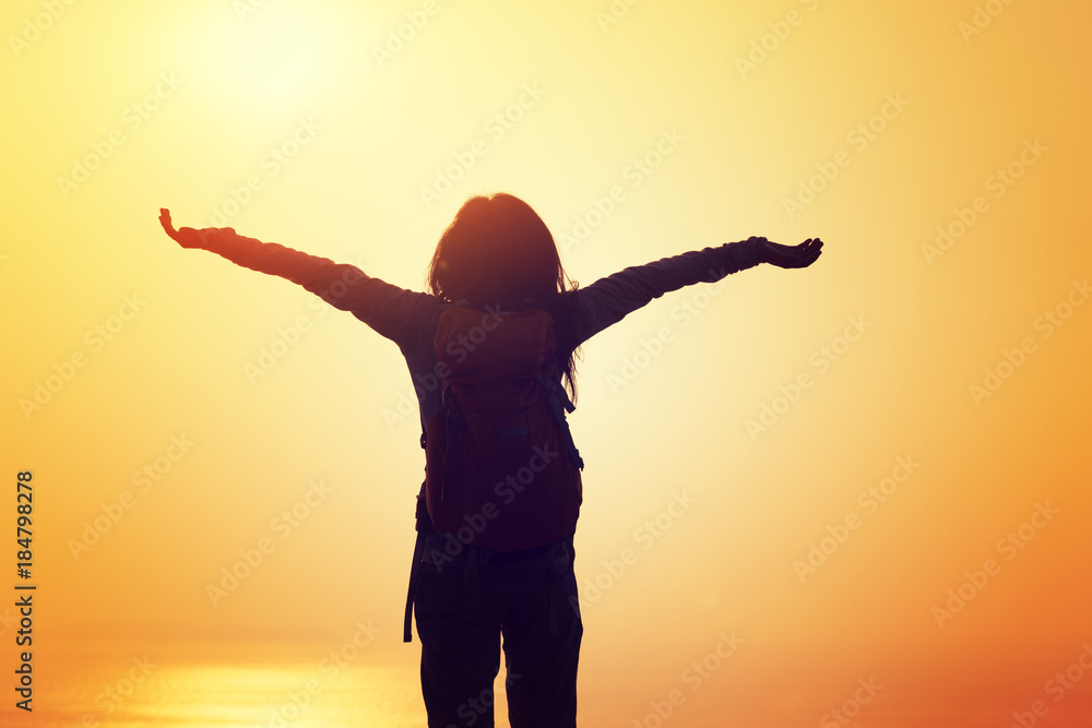 Fototapeta premium free female hiker with backpack standing on sunrise windy coast