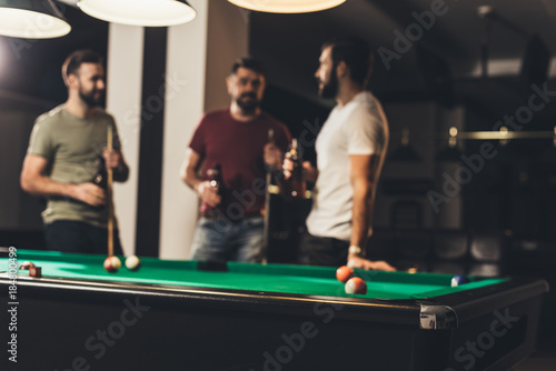 young handsome caucasian men beside billiard table in bar