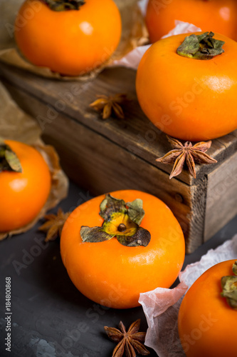 Fresh persimmon fruit on wooden table. Selective focus. Shallow depth of field.