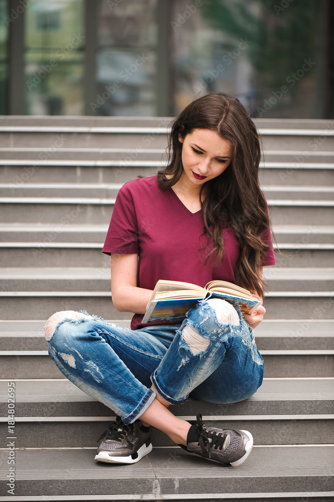 Young pretty woman sitting and reading a book enjoys of rest Young pretty woman sitting and reading a book enjoys of rest