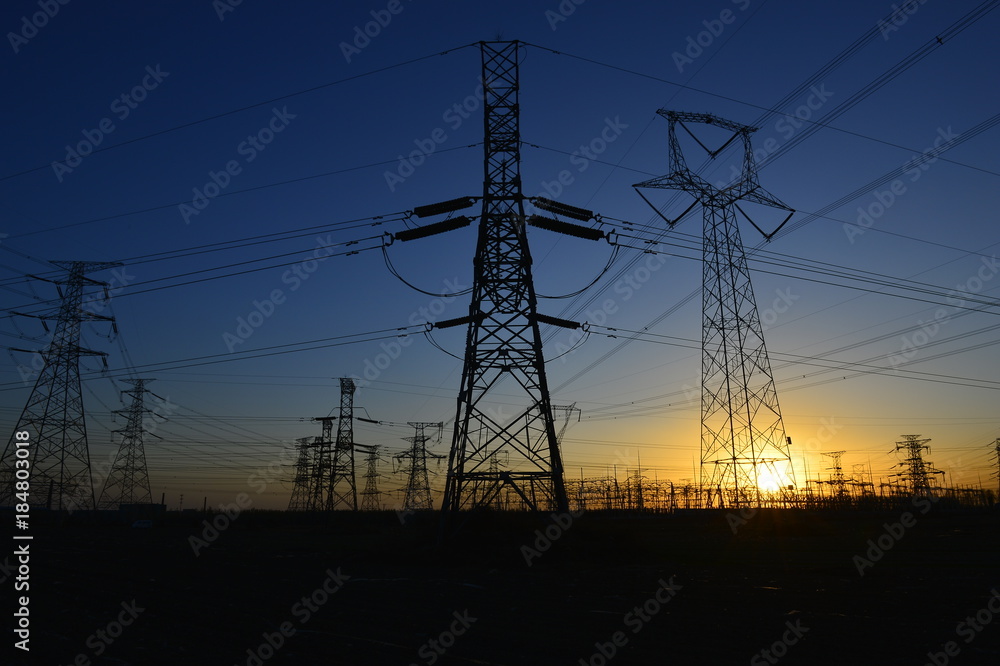 Fototapeta premium The silhouette of the evening electricity transmission pylon