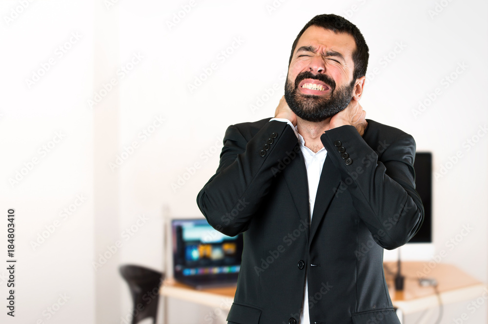 Handsome businessman with neck pain in the office Handsome businessman with neck pain in the office