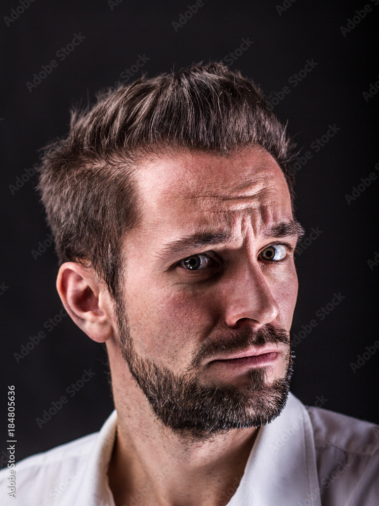 Obraz premium Ängstlicher junger Mann mit weißem Hemd