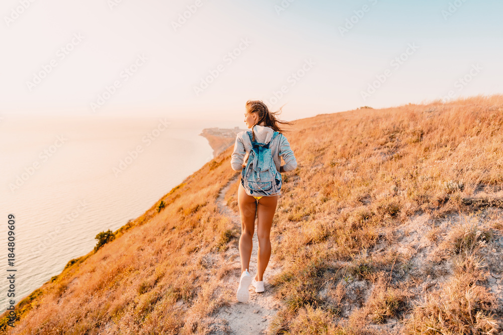 Sporty attractive woman in yellow clothes walking at cliff Sporty attractive woman in yellow clothes walking at cliff