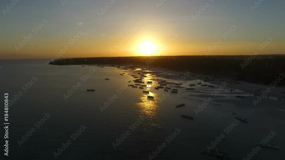 Aerial view of the sun setting behind a beautiful beach in the philippines Aerial view of the sun setting behind a beautiful beach in the philippines