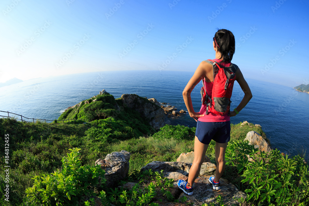 Young woman trail runner woman enjoy the view on sunrise seaside