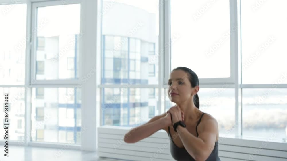 Enthusiasm and energy. Young beautiful woman doing squats while showing optimism on her face Enthusiasm and energy. Young beautiful woman doing squats while showing optimism on her face