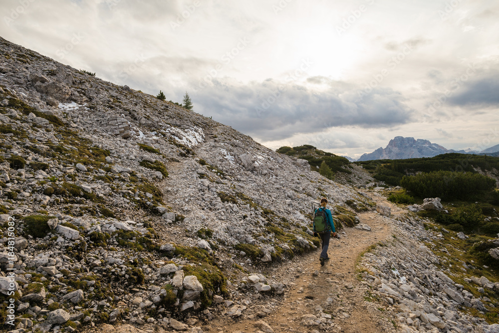 Young female hiking in the Dolomite mountains, Italy