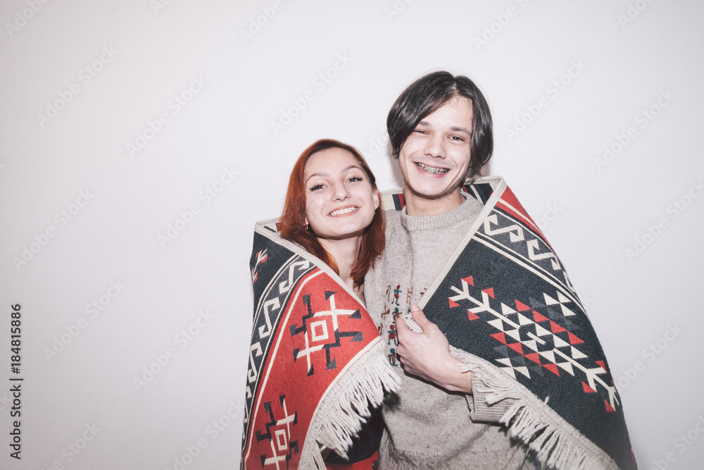 boy and girl wrapped into warm plaid on white background
